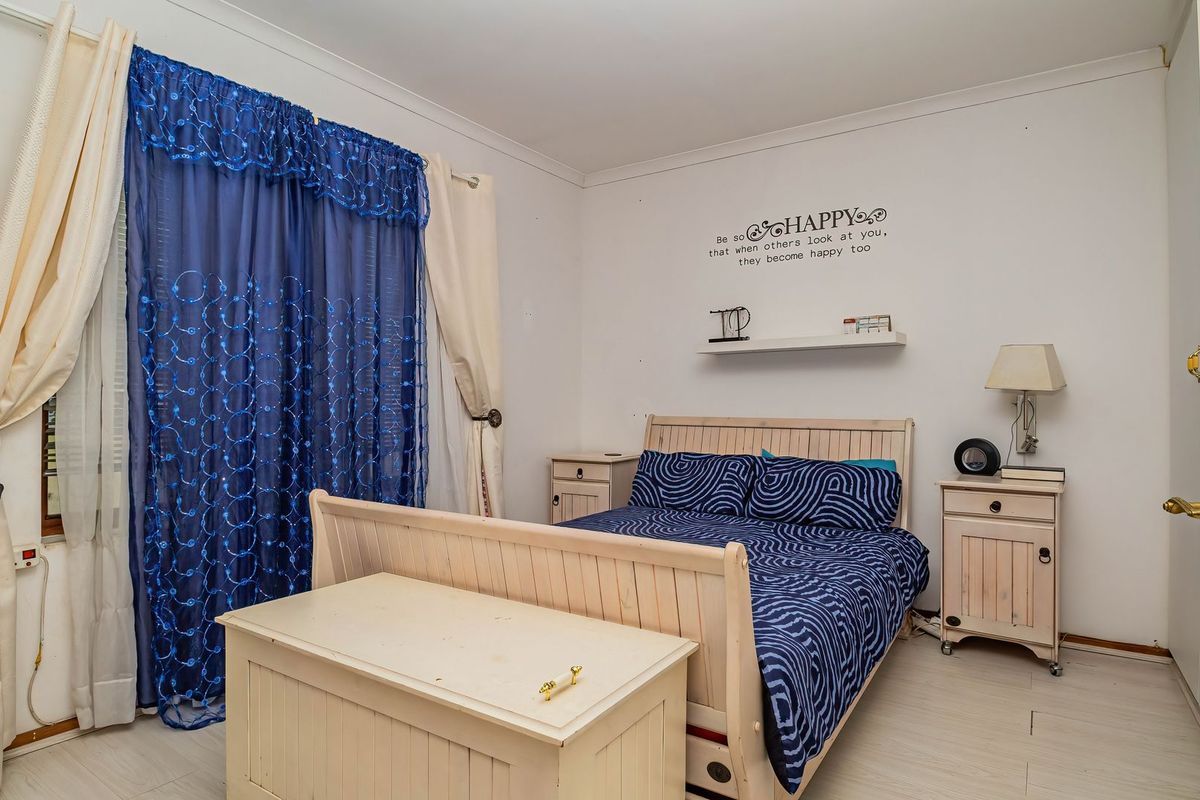 A functional bedroom featuring laminate flooring, coving, and a built-in wall shelf, offering a neutral base for personalization.