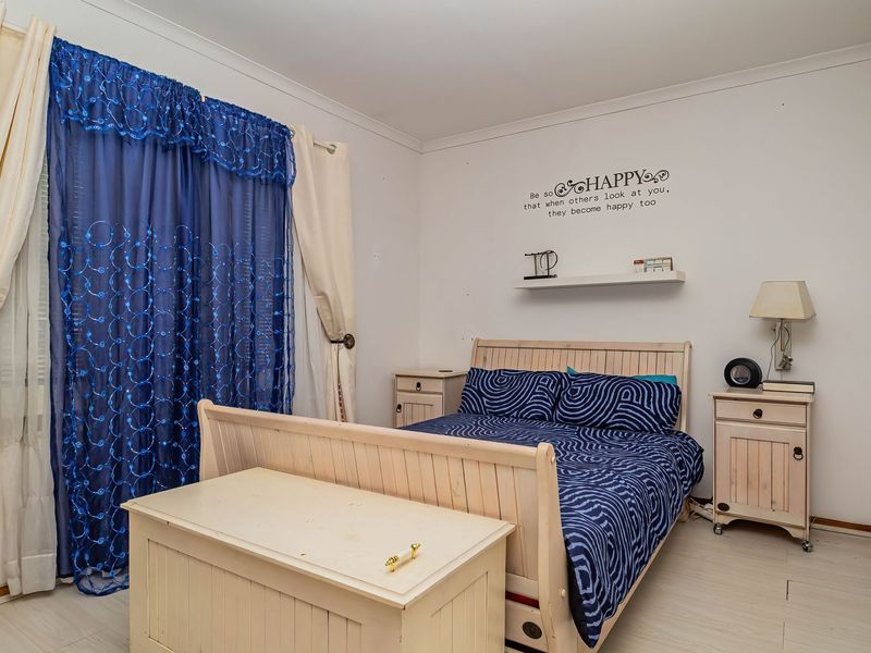 A functional bedroom featuring laminate flooring, coving, and a built-in wall shelf, offering a neutral base for personalization.