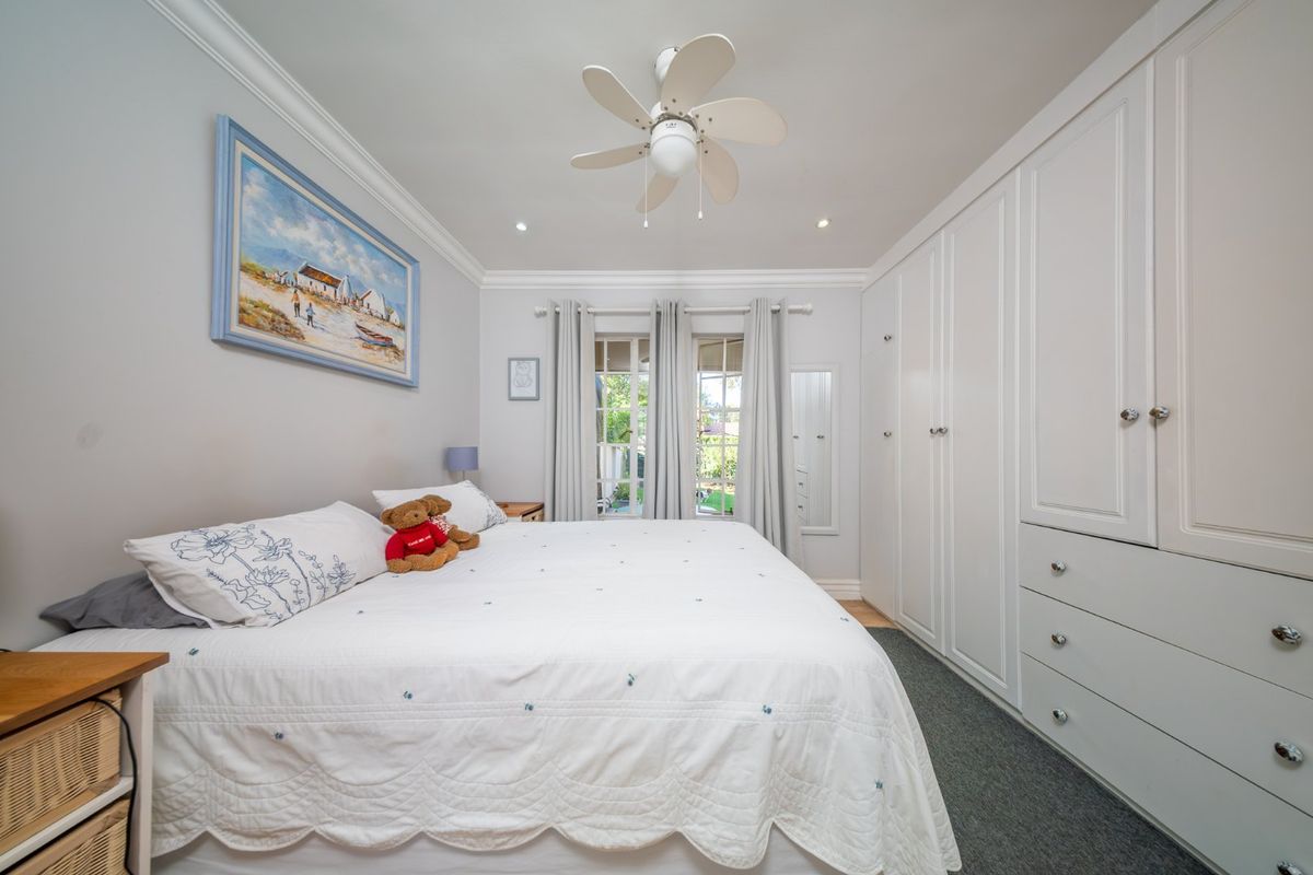 A well-maintained bedroom featuring extensive built-in cabinetry, a ceiling fan, recessed lighting, and neutral finishes.