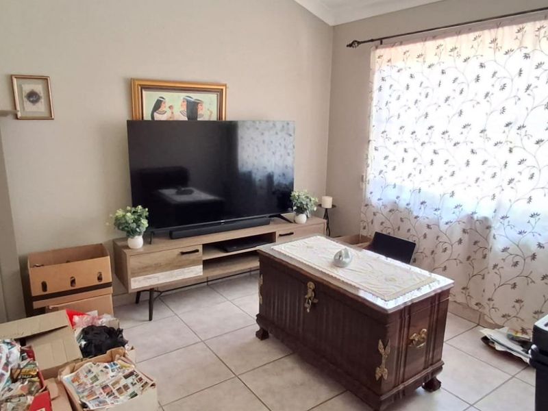 A living room featuring tiled flooring and a coved ceiling, offering a functional space ready for personalization and updated interior design.