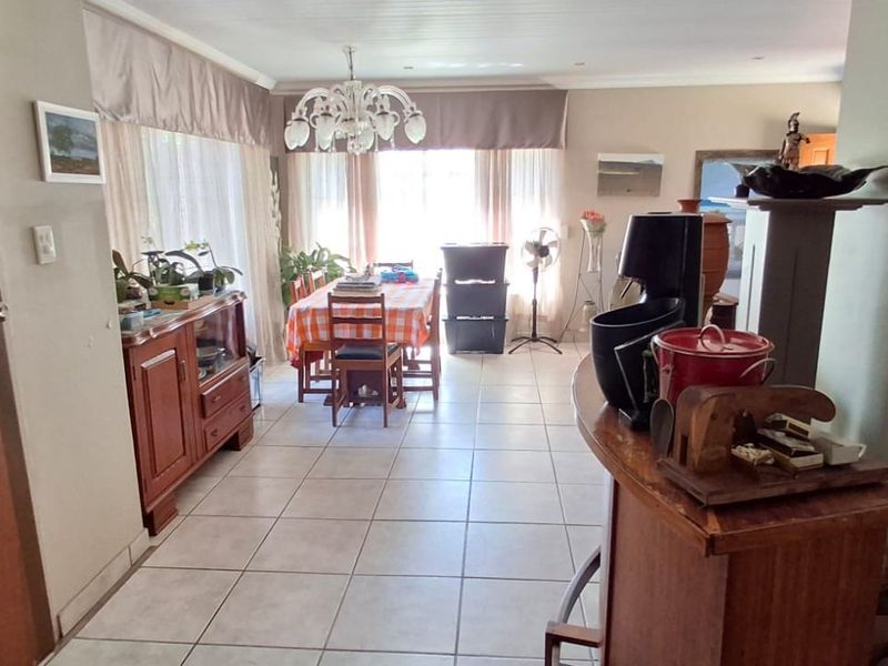 Open plan living and dining area featuring tiled flooring and recessed ceiling lighting, offering a functional space for family gatherings.