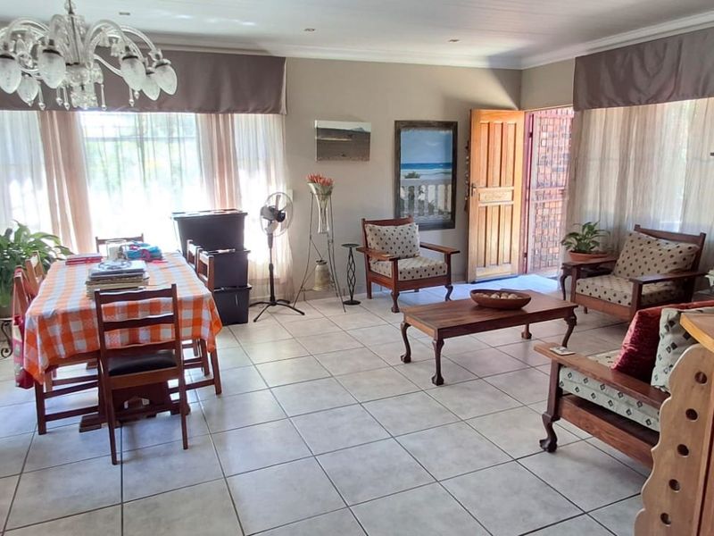 Spacious open-plan living and dining area featuring neutral tiled flooring and natural light, providing a versatile layout for family living and entertaining.