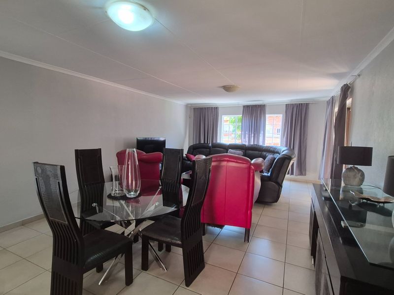 Spacious open-plan living and dining area featuring neutral wall finishes and tiled flooring throughout.