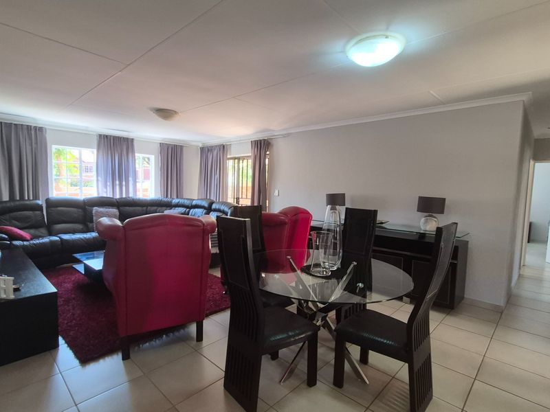 Spacious open-plan living and dining area featuring neutral tiled flooring and ample natural light, providing a versatile layout for modern apartment living.