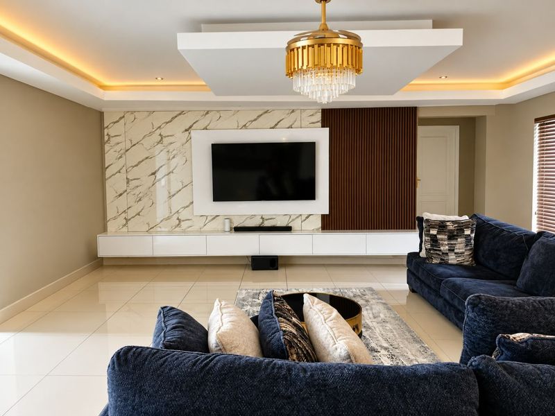 Modern living room featuring a sophisticated feature wall with marble and timber accents, floating cabinetry, and elegant recessed ceiling lighting.
