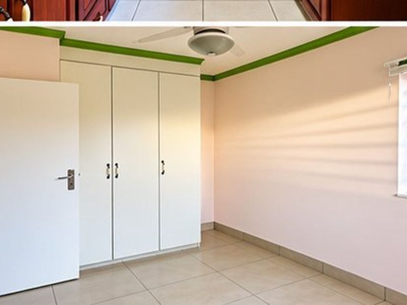 A bedroom featuring built-in cupboards, tiled flooring, and a ceiling fan, with security bars installed on the window.