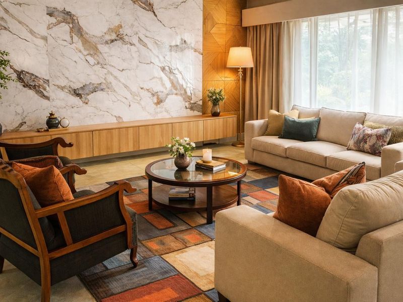 A sophisticated living room featuring a striking marble accent wall, custom built-in cabinetry, and large windows that provide ample natural light.