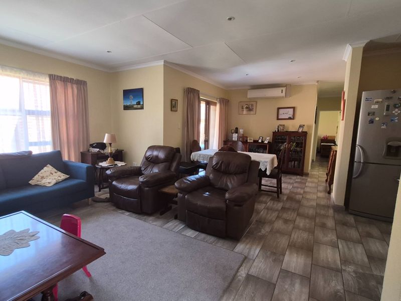 Spacious open-plan living and dining area featuring tiled flooring, recessed lighting, and an integrated air conditioning unit, offering a functional and versatile layout.