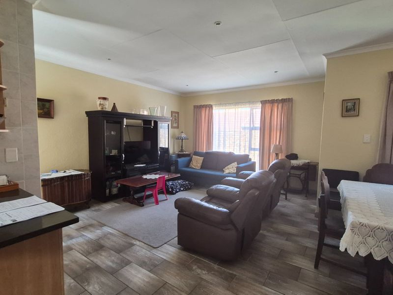Spacious open-plan living and dining area featuring tiled flooring, recessed lighting, and coved cornicing, offering a versatile layout for family living.