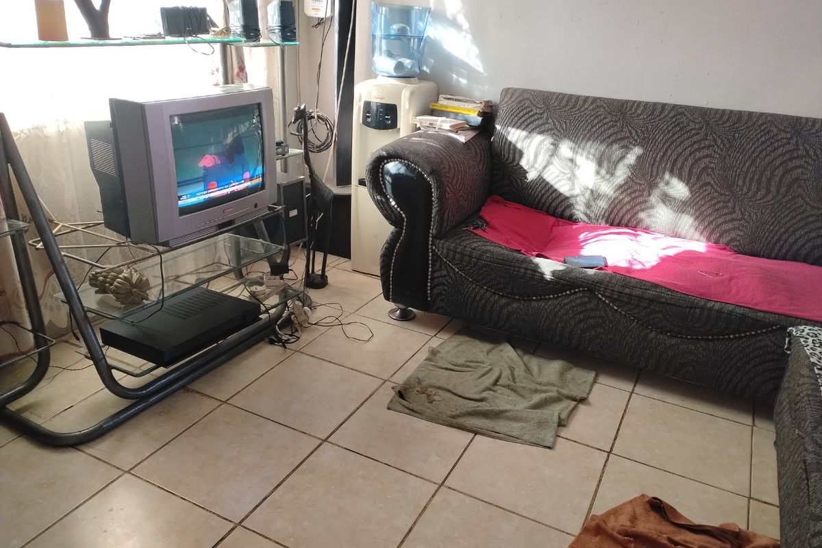 A living room area featuring ceramic floor tiles, requiring cosmetic updates to improve the overall condition and aesthetic appeal.