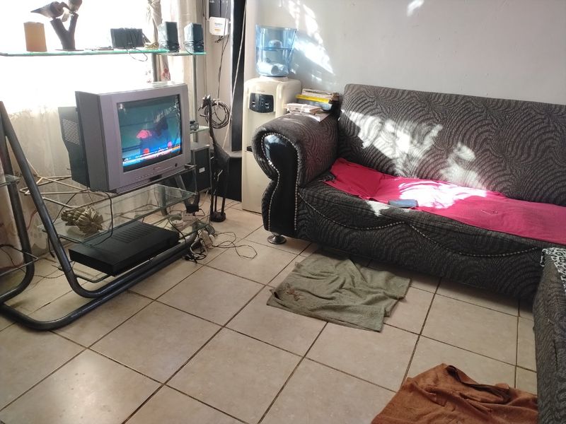 A living room area featuring ceramic floor tiles, requiring cosmetic updates to improve the overall condition and aesthetic appeal.