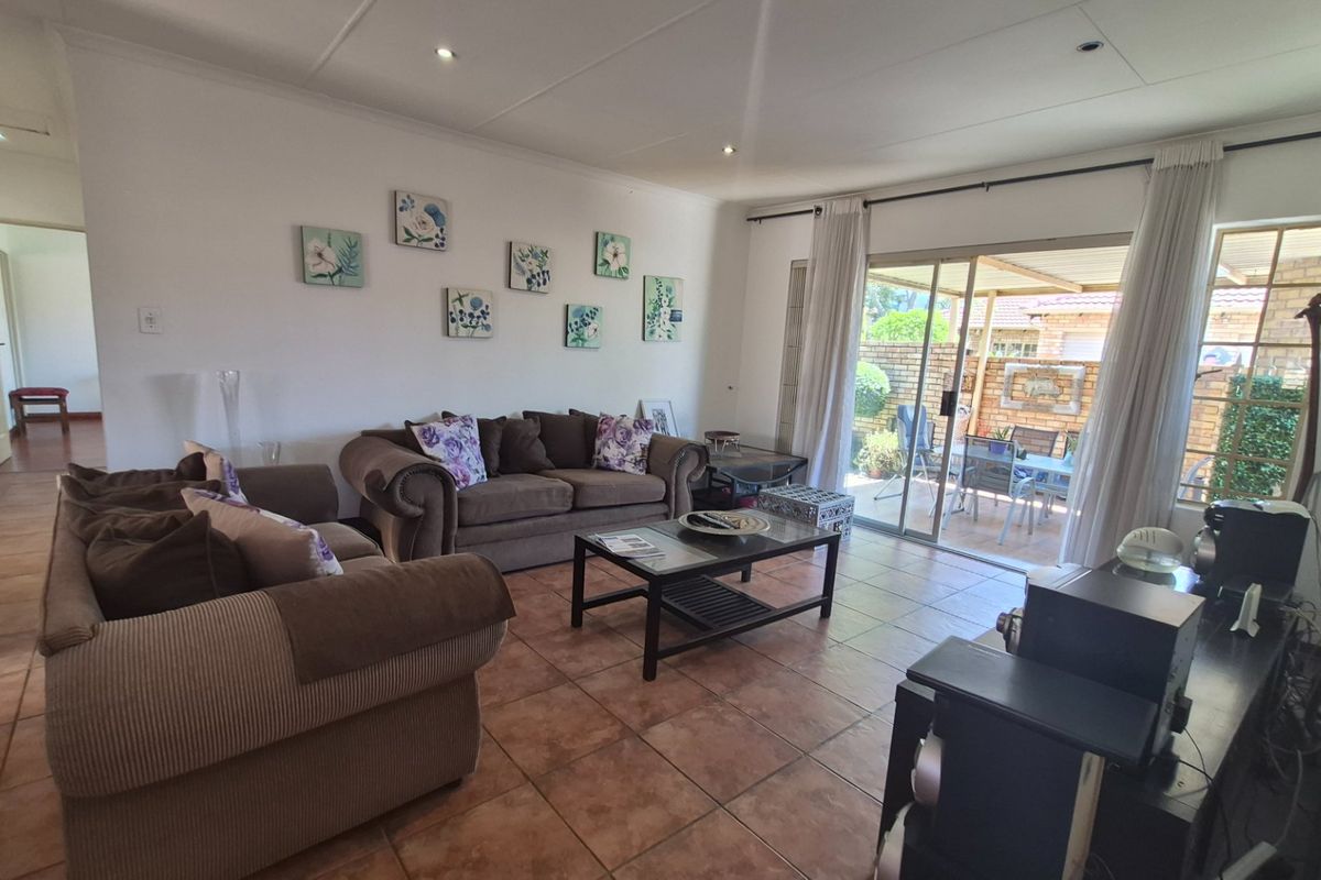 Spacious living room featuring tiled flooring and large sliding glass doors providing direct access to the outdoor patio area.