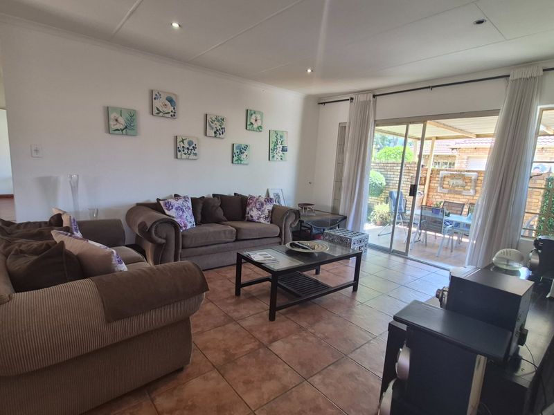 Spacious living room featuring tiled flooring and large sliding glass doors providing direct access to the outdoor patio area.