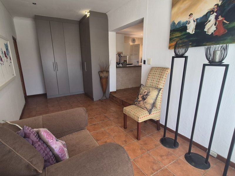 Living area featuring tiled flooring, built-in cupboards, and an open transition to the kitchen area.