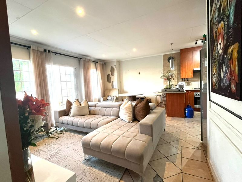 Open-plan living and kitchen area featuring tiled flooring, recessed lighting, and direct access to the outdoors through sliding glass doors.