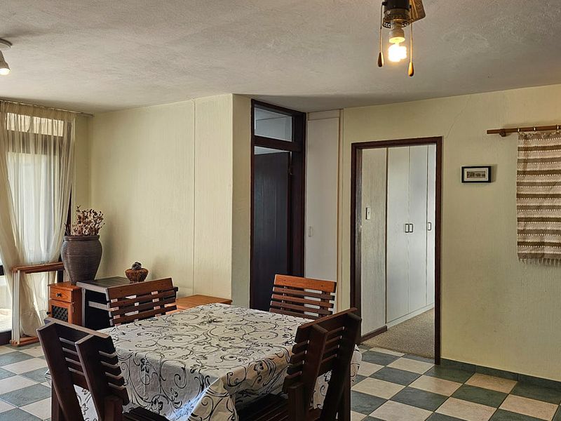 Living area featuring tiled flooring, built-in cupboards, and access to an outdoor balcony through a glass sliding door.
