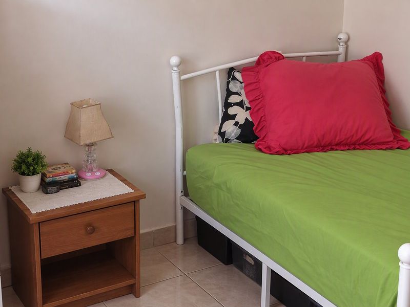 A bedroom featuring tiled flooring and neutral wall finishes, providing a functional space for rest.