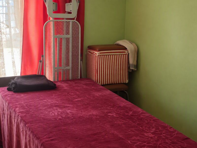 A bedroom featuring green painted walls and natural light from a window.