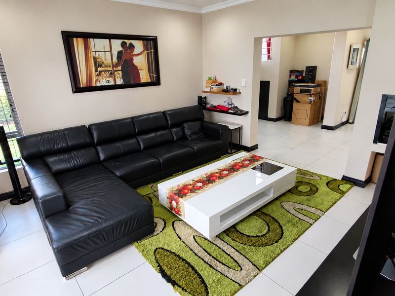 A well-maintained living room featuring neutral wall tones, tiled flooring, and decorative cove cornicing, providing a clean and functional space.