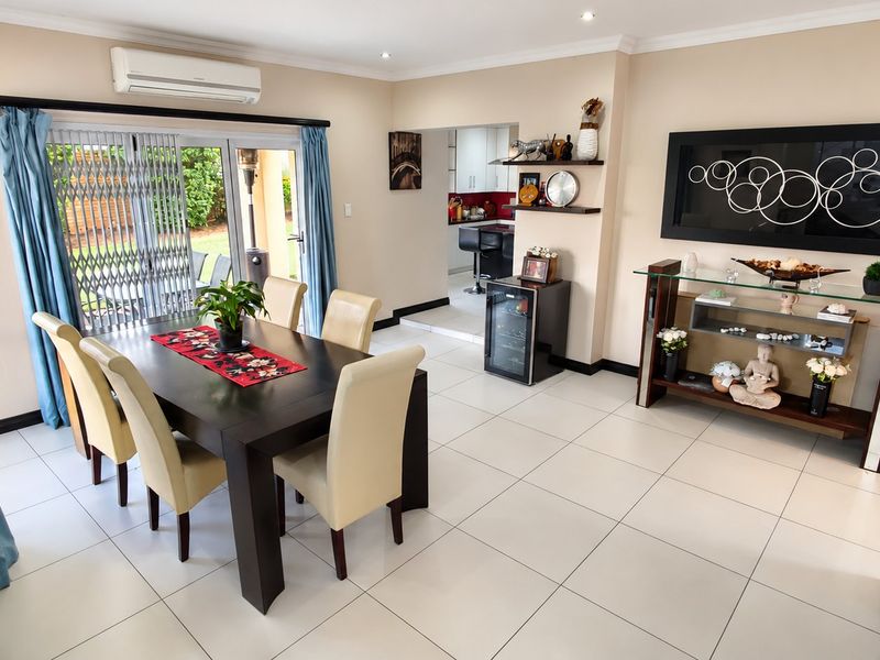 A bright dining room featuring tiled flooring, recessed lighting, and sliding glass doors that provide direct access to the outdoor patio area.