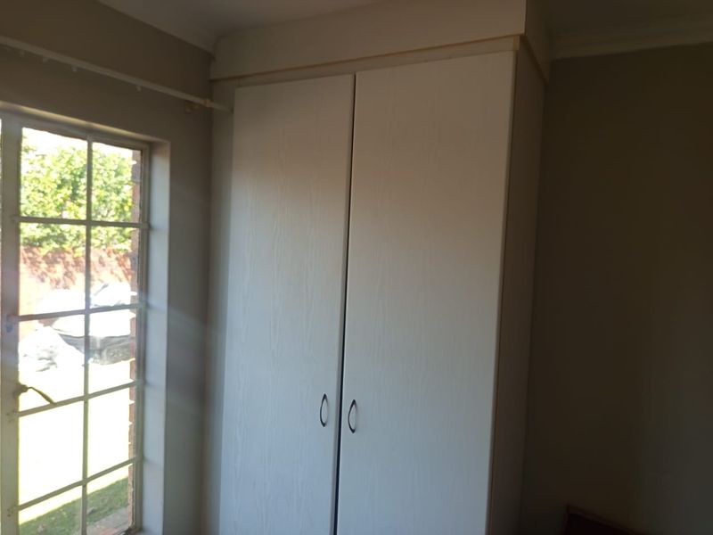 A bedroom featuring a built-in wardrobe and a window with natural light.