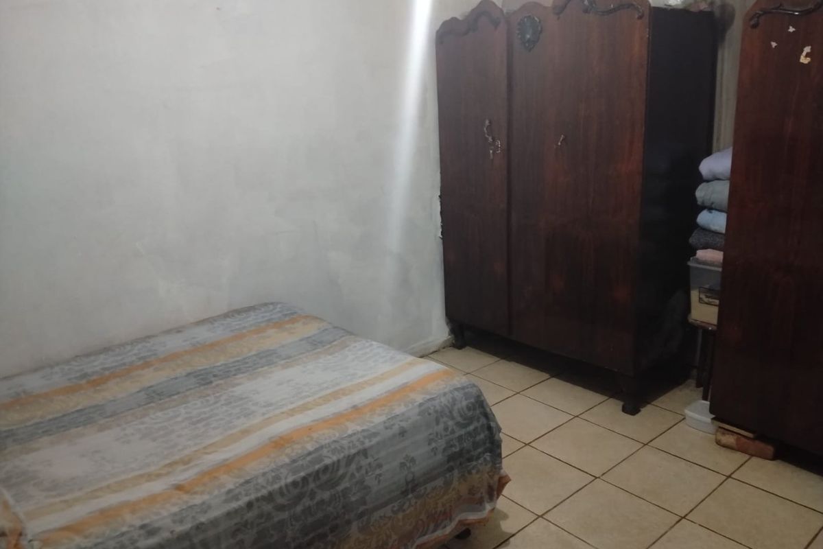 A bedroom featuring ceramic floor tiles and plain wall finishes, offering a basic space ready for cosmetic updates and modernization.