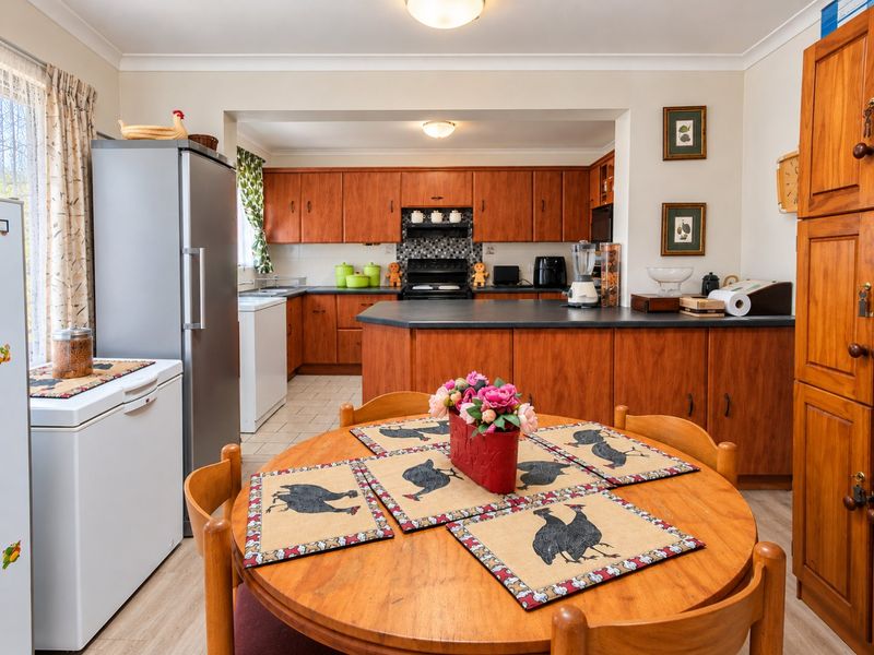 Open plan kitchen and dining area featuring traditional wooden cabinetry, laminate countertops, and a functional layout with integrated cooking appliances.