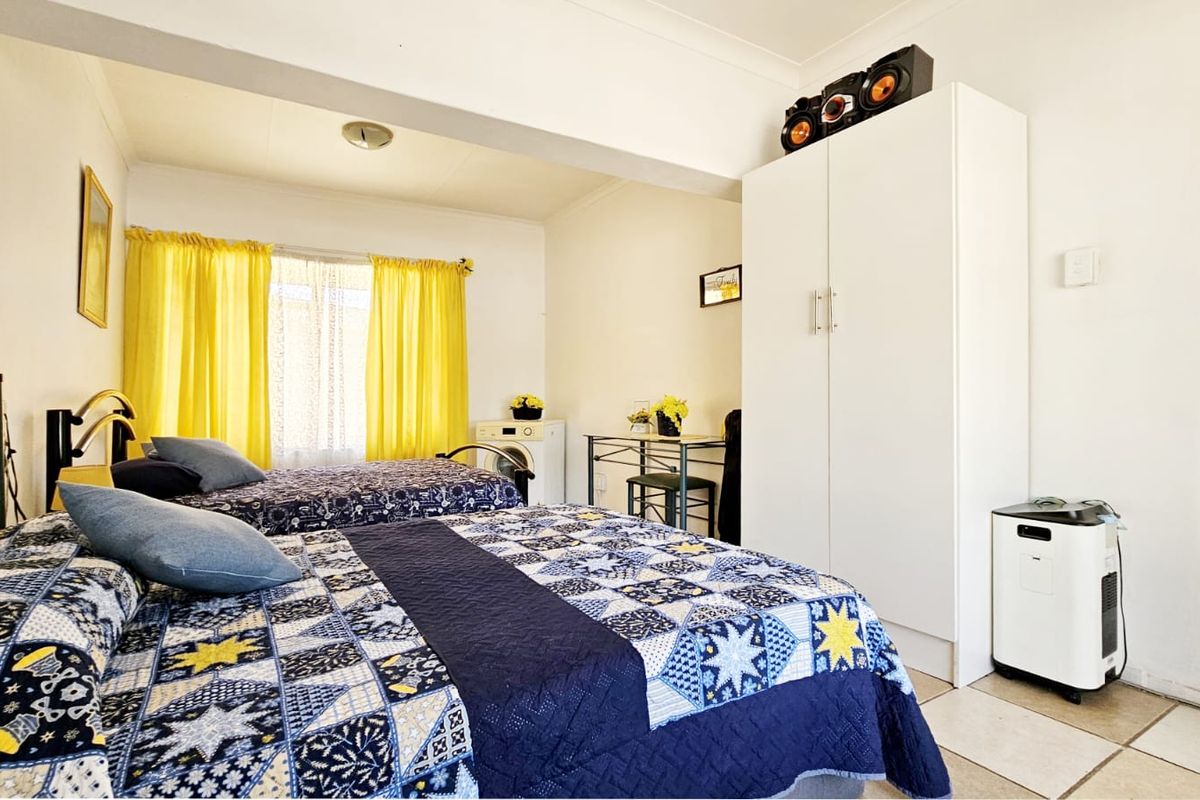 A bedroom featuring tiled flooring and a built-in wardrobe, providing functional storage space within the room.