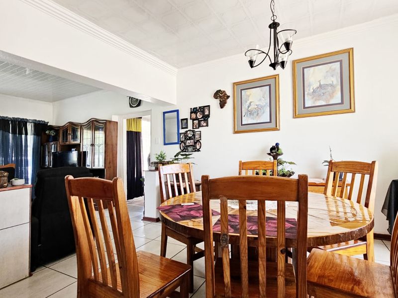 Open plan dining area featuring tiled flooring, decorative ceiling tiles, and crown molding, seamlessly connecting to the adjacent living space.