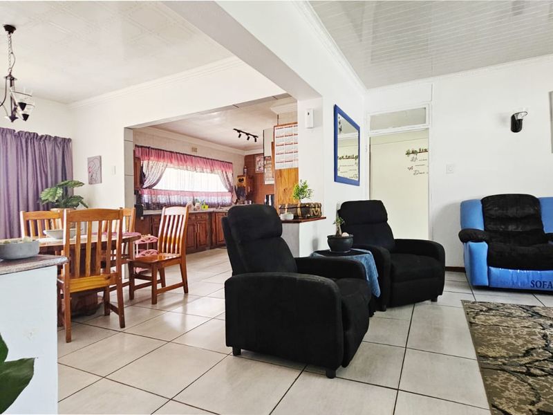 Open plan living, dining, and kitchen area featuring tiled flooring and neutral wall finishes, providing a functional and connected layout for daily living.