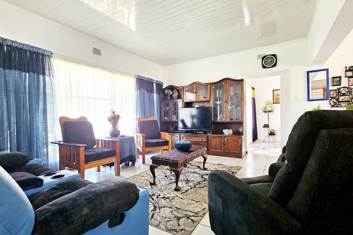 A spacious living room featuring tiled flooring and a tongue and groove ceiling, offering a comfortable and functional layout for relaxation.
