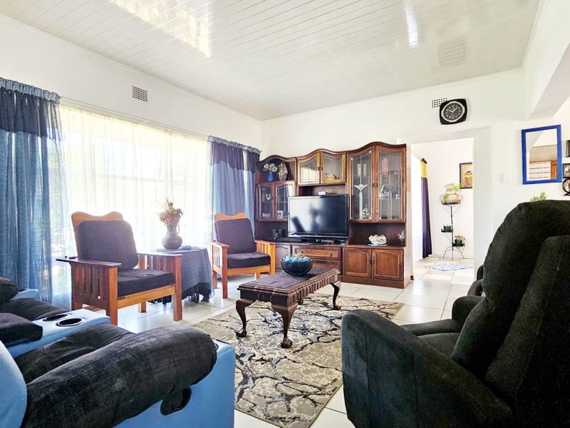 A spacious living room featuring tiled flooring and a tongue and groove ceiling, offering a comfortable and functional layout for relaxation.