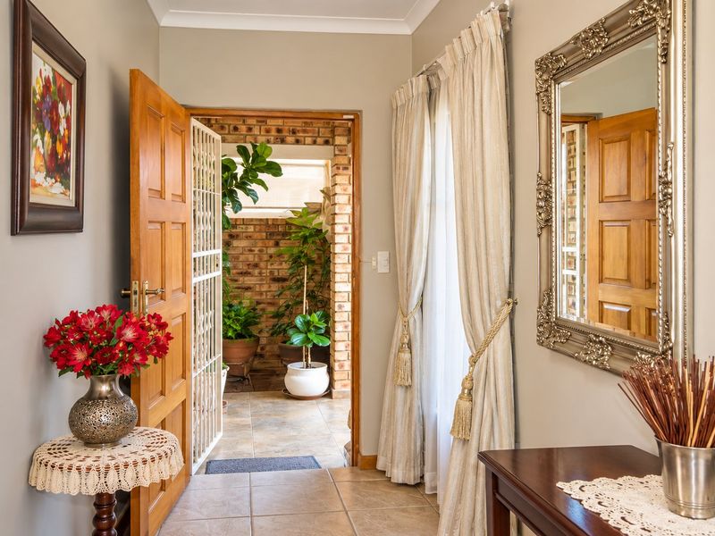 Welcoming entrance hall featuring tiled flooring and a timber door leading to an outdoor patio area.