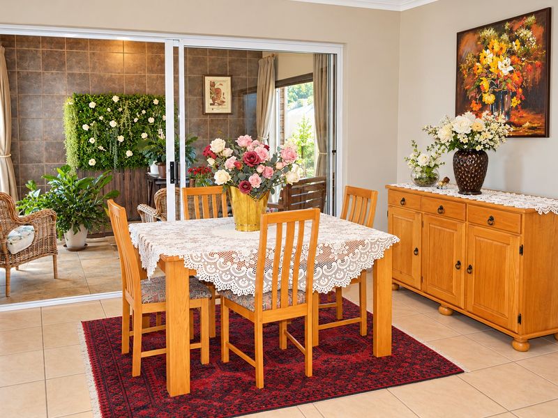 Dining area featuring tiled flooring and large sliding glass doors that provide seamless access to an enclosed patio space.