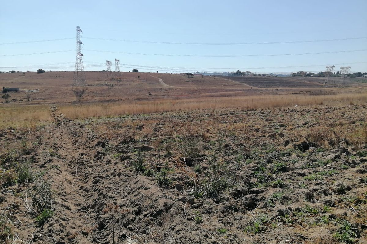 Expansive view of open farmland featuring visible high voltage transmission lines and towers crossing the landscape.