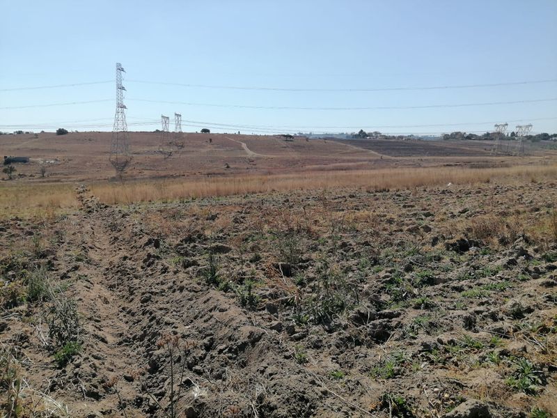 Expansive view of open farmland featuring visible high voltage transmission lines and towers crossing the landscape.