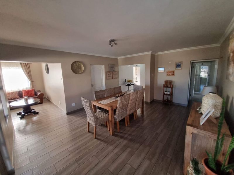 Spacious open-plan living and dining area featuring modern tiled flooring and neutral wall finishes, providing a versatile layout for family living.