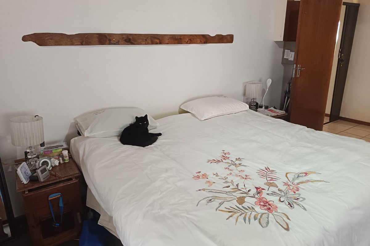 A standard bedroom featuring tiled flooring and a wooden door, providing a functional space for rest.