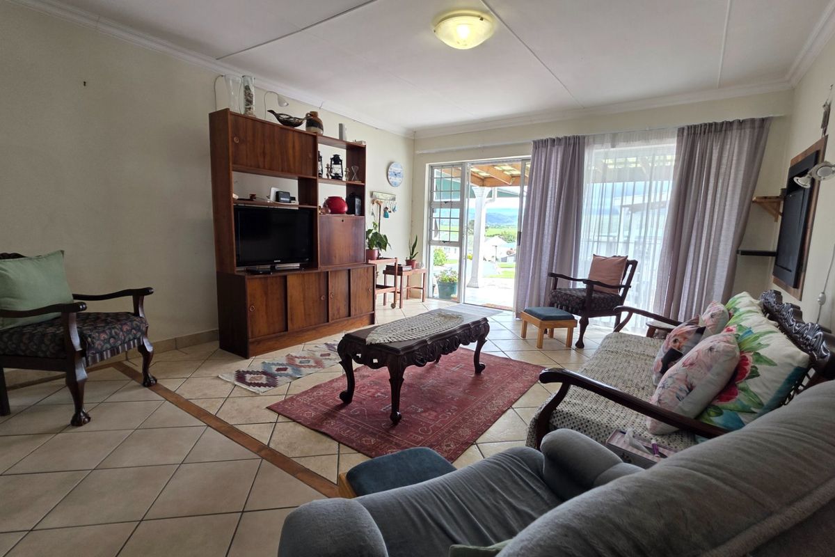 A spacious living room featuring tiled flooring and a sliding glass door that provides natural light and access to the outdoor area.