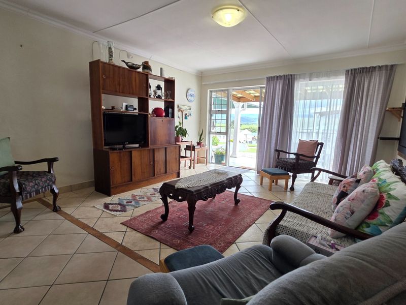 A spacious living room featuring tiled flooring and a sliding glass door that provides natural light and access to the outdoor area.
