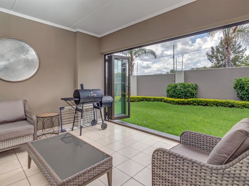 Covered patio area featuring tiled flooring and large bi-fold doors opening onto a private garden space.