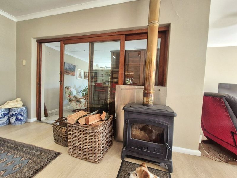 Living room featuring a cast iron fireplace with a metal flue and sliding glass doors leading to an adjacent room.