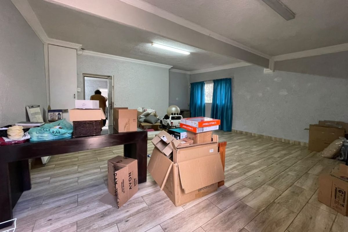 Spacious living area featuring wood-look tile flooring and built-in storage, offering a blank canvas for renovation and interior design updates.