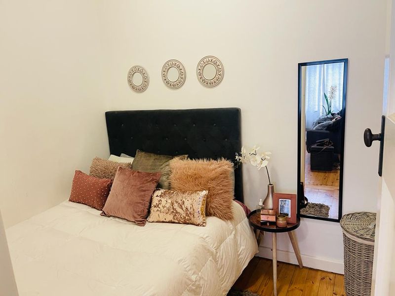 A cozy bedroom featuring warm hardwood flooring and a neutral wall finish, providing a comfortable and inviting sleeping space.