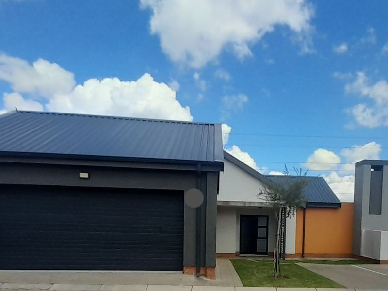 Front elevation of a modern house featuring a dark metal roof, integrated garage, and paved driveway with a clean, contemporary facade.