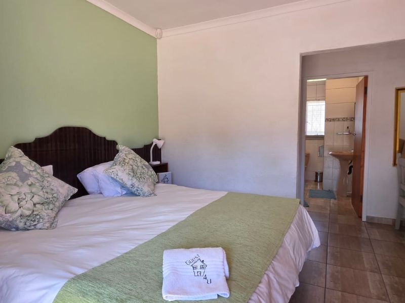 A bedroom featuring tiled flooring and an en-suite bathroom, providing a functional and comfortable space for guests.