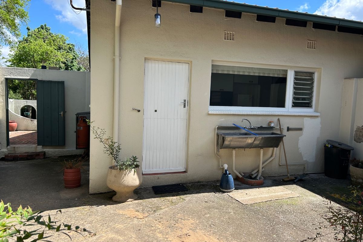 Rear exterior view of the property featuring a concrete patio area, an external utility sink, and access to the rear garden.