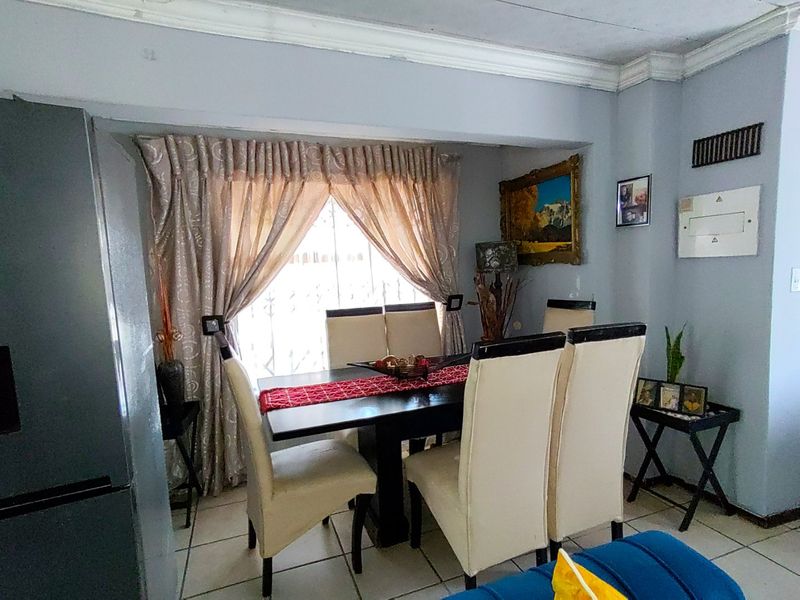 A dining area featuring tiled flooring and ceiling cornice detailing, providing a functional space for family meals.