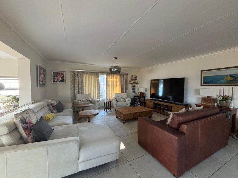 A spacious living room featuring tiled flooring and a neutral color palette, offering a comfortable and functional area for relaxation.