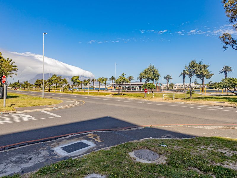 A street view showing the surrounding neighbourhood infrastructure, road access, and local landscape with a clear view of the mountain in the distance.